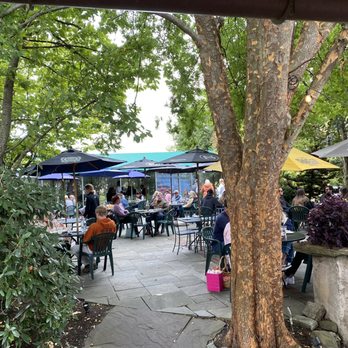 Four Dogs Tavern - people sitting at tables under umbrellas - American Near Me - West Chester, Pennsylvania Four Dogs Tavern - people sitting at tables under umbrellas - American Near Me - West Chester, Pennsylvania