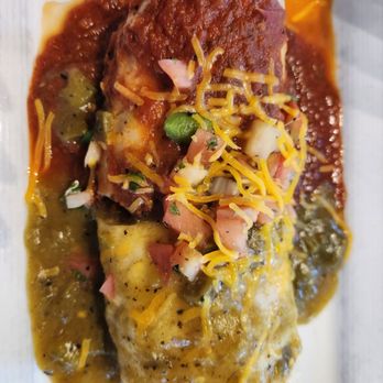 Over Easy - Gilbert - A baked dish with melted cheese, sauce, and garnishes, served on a white plate, likely from a restaurant specializing in comfort food. - Breakfast & Brunch Near Me - Gilbert, Arizona
