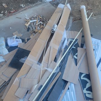 Design Time - Garbage left for the homeowner to clean up - A pile of construction materials, including wood, metal, and cardboard, is scattered outside a building under construction. - Carpeting Near Me - Redding, California