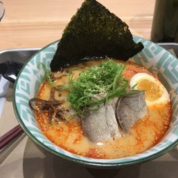 a bowl of ramen with an egg and garnish