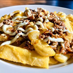 Mason Dixon Cafe - Loaded steak fries topped with seasoned cheesesteak meat, grilled onions, truffle cheese sauce, and roasted garlic truffle ai...