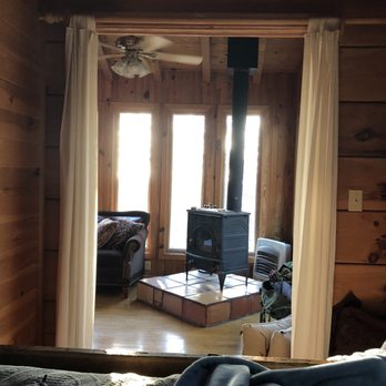 Cottages At Spring House Farm - View of wood burning stove and sunrise from the bed - Hotels Near Me - Marion, North Carolina