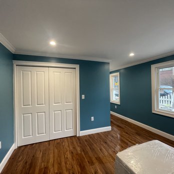 Danny’s renovation - a bedroom with blue walls and hardwood floors - General Contractors Near Me