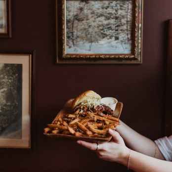 Tin Fiddler - a woman holding a plate of food - Pubs Near Me - Sarnia, Ontario Tin Fiddler - a woman holding a plate of food - Pubs Near Me - Sarnia, Ontario