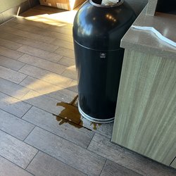 Starbucks - Overfilled trash can with an unattended spill on the floor.