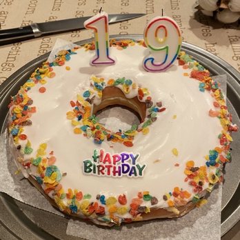 Donut Drop - Vanilla iced donut cake with fruity pebbles (I added the Happy Birthday sign and candles myself) - Donuts Near Me - Schaumburg, Illinois Donut Drop - Vanilla iced donut cake with fruity pebbles (I added the Happy Birthday sign and candles myself) - Donuts Near Me - Schaumburg, Illinois