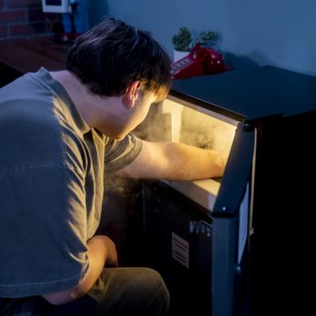 Just Escape Room - A man reaching into a smoking machine - Escape Games Near Me - LaGrange, Illinois Just Escape Room - A man reaching into a smoking machine - Escape Games Near Me - LaGrange, Illinois