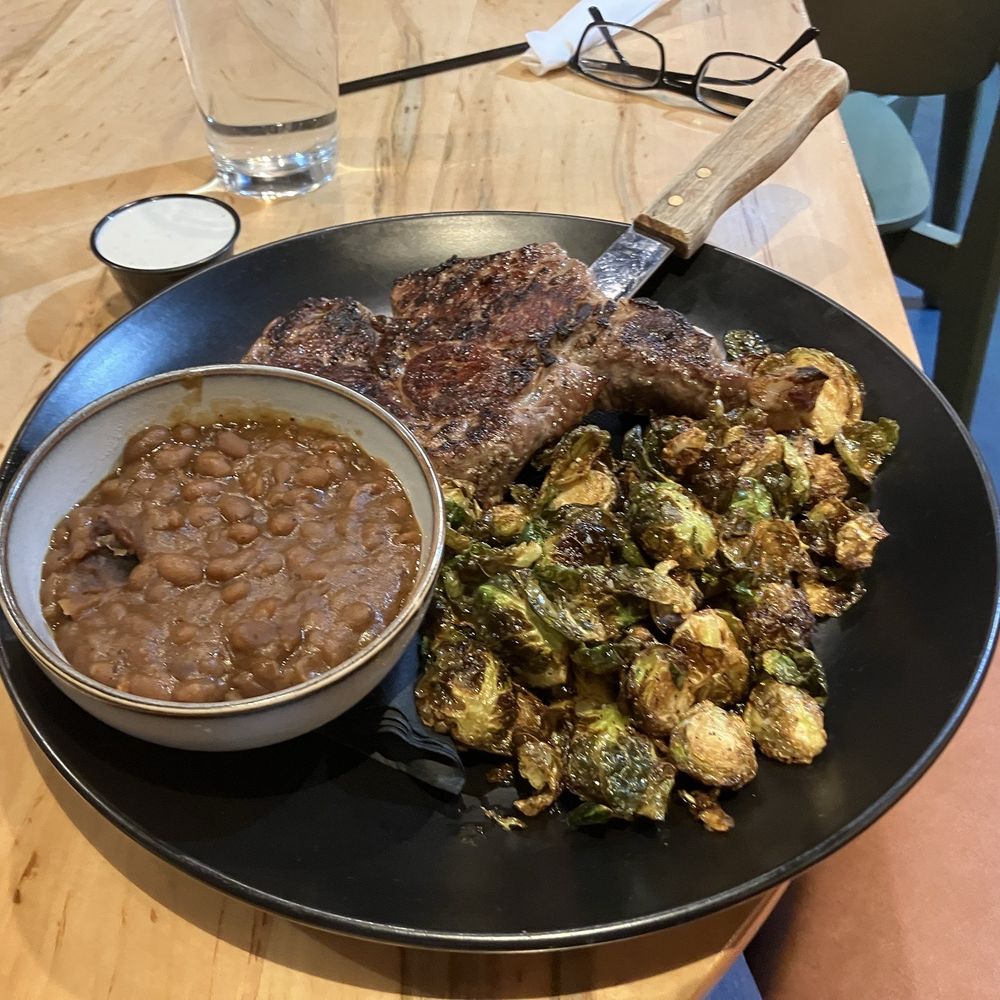 Sandman Grill - Chimichurri Ribeye with baked beans and Brussels sprout. Steak is very good with baked beans and their house marinara on top. - Sports Bars Near Me - Hampton, Virginia