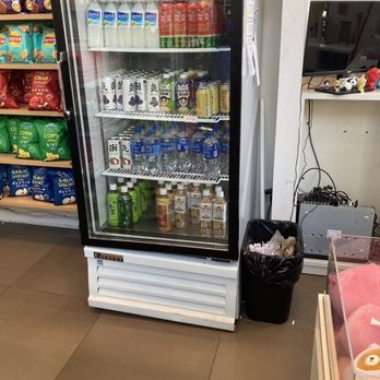 Miniso - A glass-front refrigerated display case contains bottled beverages, including water, juice, and tea, in a convenience store setting. - Department Stores Near Me - Pasadena, California