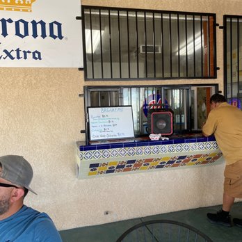 La Plaza - a man in a blue shirt and hat standing in front of a corona extra sign - Convenience Stores Near Me - Madera, California La Plaza - a man in a blue shirt and hat standing in front of a corona extra sign - Convenience Stores Near Me - Madera, California