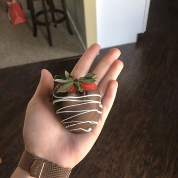 Edible Arrangements - a hand holding a chocolate covered strawberry - Gift Shops Near Me - O Fallon, Missouri