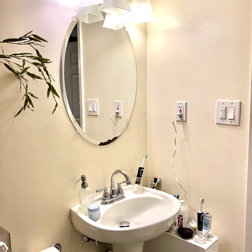 BEFORE: guest bathroom with a makeshift storage solution next to the pedestal sink
