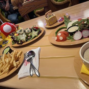 Toadstool Cafe - (Left) Luigi Burger & Yoshi's Favorite Fruit and Veggie Salad (Middle) ? Block Tiramisu (Right) Super Mushroom Soup & Piranha Plant Caprese - Cafes Near Me - Universal City, California