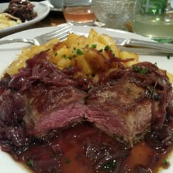 Rostbraten mit Bratkartoffeln und in Portweinsauce geschwenkten Zwiebeln.