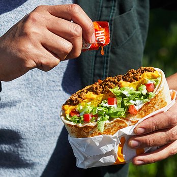 Taco Bell - a person holding a burrito - Fast Food Near Me - Lompoc, California Taco Bell - a person holding a burrito - Fast Food Near Me - Lompoc, California