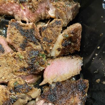 Outback Steakhouse - a close up of a steak in a pan - Steakhouses Near Me - San Antonio, Texas