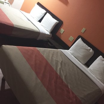 Motel 6 - Double beds, raised platforms, end table with two shelves. Bar light above each bed - Hotels Near Me - Troutville, Virginia