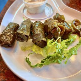 Dolma (6 pcs)... Vegetarian grape leaves stuffed with rice and herbs. Served with tzatziki sauce. Dolma (6 pcs)... Vegetarian grape leaves stuffed with rice and herbs. Served with tzatziki sauce.