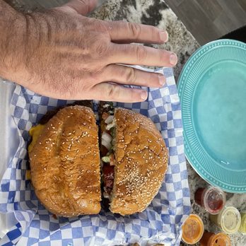 Cowboy Tacos and Burgers - a hand reaching for a burger - Food Trucks Near Me - Conroe, Texas Cowboy Tacos and Burgers - a hand reaching for a burger - Food Trucks Near Me - Conroe, Texas
