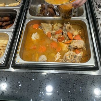Luna Hall - a person serving food at a buffet - Food Court Near Me - Wheaton-Glenmont, Maryland Luna Hall - a person serving food at a buffet - Food Court Near Me - Wheaton-Glenmont, Maryland