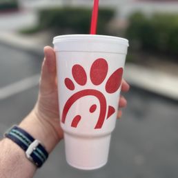 ows a hand holding a cup with a straw