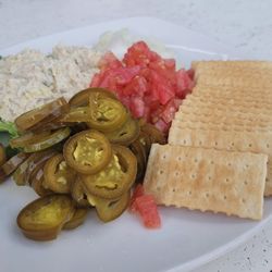 SMOKED FISH DIP & CRACKERS ($12.25): Soda crackers and mahi fish dip. Served with jalepenos and tomato.