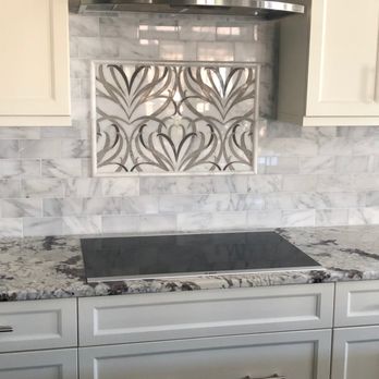 John A Burghoffer Construction - a kitchen with white cabinets and marble countertops - Masonry/Concrete Near Me - Caswell Beach, North Carolina John A Burghoffer Construction - a kitchen with white cabinets and marble countertops - Masonry/Concrete Near Me - Caswell Beach, North Carolina