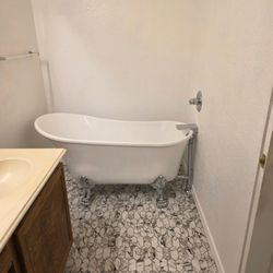 Hawaii Elite Painting & Renovations - Tile floor installed guarding tub with polished chrome fixtures