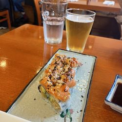 Hinode Japanese Restaurant - Shrimp tempura roll with avocado and seasoned salmon topping.