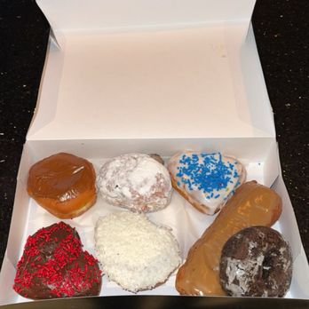 Mr Maple Donuts - A white box contains eight donuts with different toppings, including caramel, blue sprinkles, red sprinkles, shredded coconut, and powdered sugar. - Donuts Near Me - Phoenix, Arizona