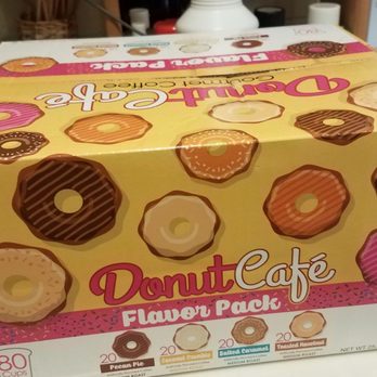 Ollie's Bargain Outlet - 80 KCups for $18 - A rectangular box of Donut Café flavored coffee pods is shown, decorated with illustrations of various donuts such as glazed, chocolate, and sprinkled types. The box contains 80 cups and is designed for coffee brewing. The packaging emphasizes donut-themed flavors and includes branding and product details. - Discount Store Near Me - Barkhamsted, Connecticut