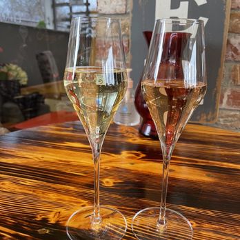 Simply Bubbles - two glasses of wine on a wooden table - Champagne Bars Near Me - Sutter Creek, California