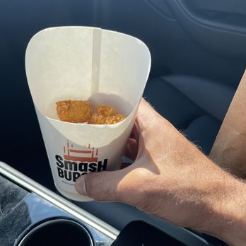 Smashburger - a hand holding a paper cup of food - Burgers Near Me - Westminster, Colorado