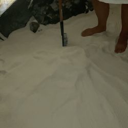 Hood River Salt Cave - Client Zen raking in the salt while creating a floor design before she lays on the sea salt to create her salt angel.