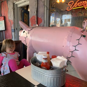 Daddy D'z BBQ Joynt - a little girl sitting in front of a pink cow - Barbeque Near Me - Atlanta, Georgia