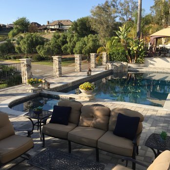 A Omega Construction - a patio with a pool in the background - Landscaping Near Me A Omega Construction - a patio with a pool in the background - Landscaping Near Me