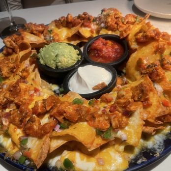 Moxies - 1 LB cheese nachos with guac, pico de gallo and blackened chicken. Delicious and big portion, had to take some to go - Cocktail Bars Near Me - Houston, Texas