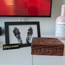 A wooden box containing the ashes of our pet rabbit, along with a print of her back feet and a name plate.