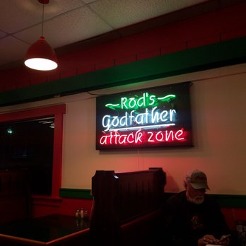 Rod's Pizza Cellar - a man sitting at a table in front of a neon sign - Italian Near Me - Hot Springs, Arkansas