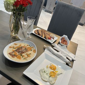 Rayne Restaurant & Lounge - Maple glazed salmon over cheese grits with a side of over easy eggs and French toast with a side of bacon - Lounges Near Me - Baltimore, Maryland