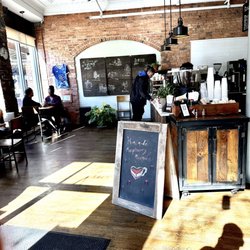 The Coffee Box - Barista counter and small tables along the entrance. There are more seats on the opposite side as well.