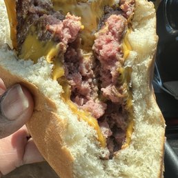 a person holding a sandwich in their hand a person holding a sandwich in their hand