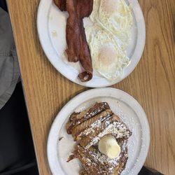 Eggs, bacon and French toast with powdered sugar