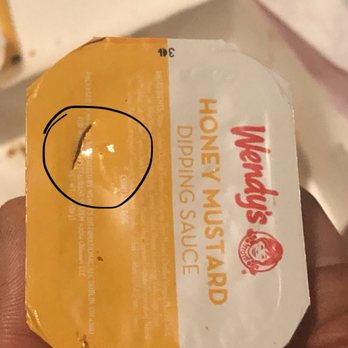 Wendy's - a hand holding a package of honey mustard - Fast Food Near Me - Austin, Texas Wendy's - a hand holding a package of honey mustard - Fast Food Near Me - Austin, Texas