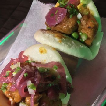 Slainte of Peekskill - Two steamed bao buns filled with fried chicken, pickled red onions, and chopped green onions, served on a paper-lined tray. - Irish Pub Near Me - Peekskill, New York