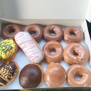 Krispy Kreme - Assorted dozen $10.99 (The 4 glazed ones at the top are pumpkin spice donuts *limited time*) . - Donuts Near Me - Long Beach, California