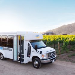 Discover Tehachapi - A Discover Tehachapi bus in front of grape vines at Triassic Vineyards.