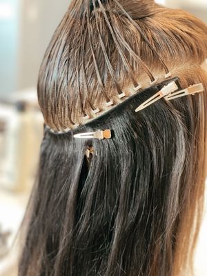 Extensions - IBE® Hair Extensions -$2,500-$4,000
$2,500-$4,000 ・ 9 hr
IBE® Hair Extensions Pricing 

Pricing for IBE® (Invisible Bead Extensions) is fully customized and varies based on each client’s unique needs and desired outcome. Several factors go into your final investment to ensure the most seamless, natural-looking result.

Your total price may vary based on:
	1.	Extension Hair – This includes the cost of the hair itself, which depends on the length, color match, and any prep work needed (such as custom coloring, toning, or blending the extension hair prior to installation).
	2.	Color Service (Your Natural Hair) – Any blonding, color correction, glossing, or root work needed to ensure your natural hair blends flawlessly with your extensions.
	3.	Installation – The initial install is $300 per row, with the number of rows determined during your consultation based on your desired fullness and length.
	4.	Cut & Blending – Custom shaping and blending to ensure the extensions look completely natural and undetectable.
	5.	Style – A finished style so you leave feeling confident and polished.
What’s Included:
Your investment for hand-tied IBE® extensions is all-inclusive—this covers the hair, color, install, cut, and final style—so there are no surprises, just beautiful results tailored to you.

Deposit Policy:
A $500–$1000 non-refundable deposit is required to secure your appointment and order your custom extension hair. This deposit will be invoiced to you directly.

Please note:
If you no-show your appointment, your deposit will be forfeited, and your hair will not be provided or refunded.