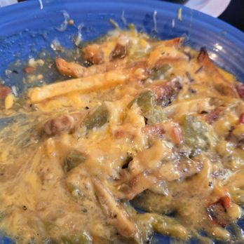 Lindy's Diner - Green chile cheese fries - A blue bowl contains green chile cheese fries topped with melted cheese, jalapeños, and bacon bits, typical of New Mexican cuisine. - Diners Near Me - Albuquerque, New Mexico