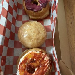 In front : mango tajin cronut( june flavor ) , middle: plain glazed brioche doughnut  and in the back blackberry lime cronut (june flavor)